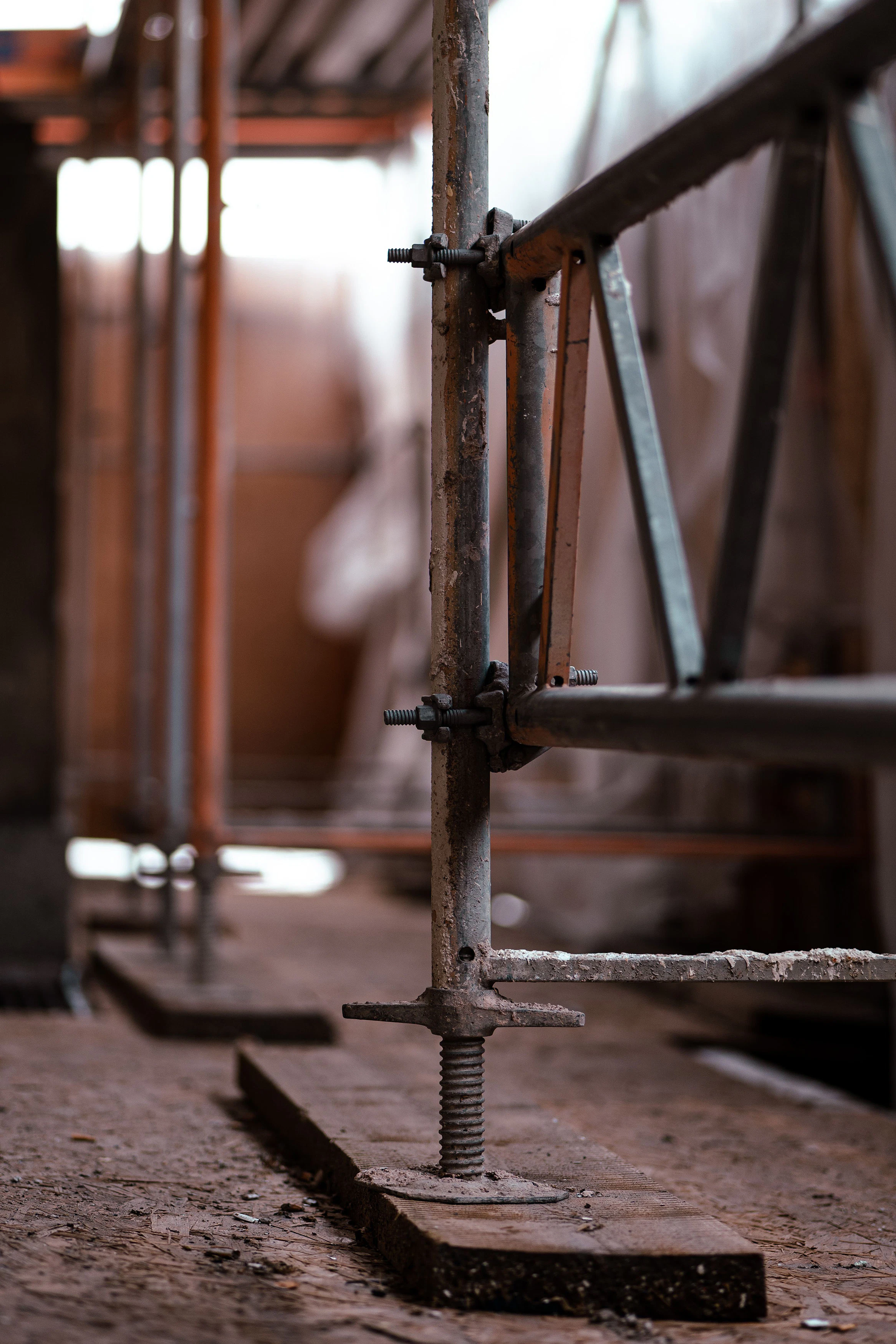 Close-up of a scaffold base at a NYC construction site, illustrating structural support and safety standards under Local Law 48 and Local Law 51 of 2025.